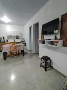 een woonkamer met een tafel en een televisie bij Casa temporada estrela do mar in Imbé