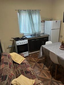 a kitchen with a couch and a table and a refrigerator at Alojamiento Del Valle in San Fernando del Valle de Catamarca
