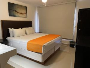a bedroom with a large bed in a room at Hotel Presidente Tijuana in Tijuana