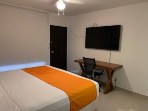a bedroom with a bed and a desk and a flat screen tv at Hotel Presidente Tijuana in Tijuana +21 photos