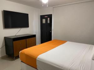 a bedroom with a bed and a flat screen tv at Hotel Presidente Tijuana in Tijuana