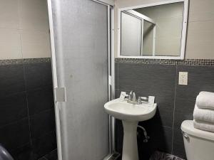 a bathroom with a sink and a shower with a mirror at Hotel Presidente Tijuana in Tijuana