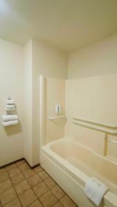 a white bathroom with a tub and towels at Rodeway Inn Jackson in Jackson