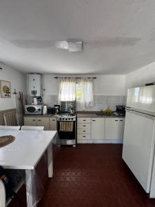 une cuisine avec des armoires blanches et un four à plaques de cuisson dans l'établissement La Chuña, à Villa Los Aromos