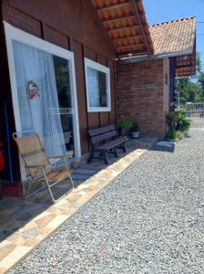 een bankje op de veranda van een huis bij Pousada do vô Bi 02 in São Francisco do Sul