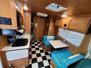 una piccola cucina con pavimento a scacchi in un camper di Gold Rush Historical Resort a Sonora
