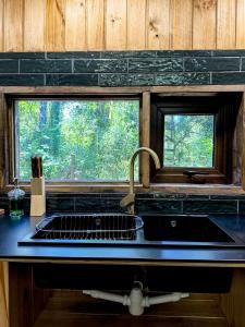 eine Küchentheke mit Spüle und Fenster in der Unterkunft Cabañas Mountain Fox Chilote - Acceso al Lago - Ensenada in Puerto Varas + 15 Fotos
