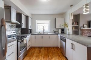 een keuken met witte kasten en een houten vloer bij Beautiful & Spacious Apt AC, Unit #1 in Halifax