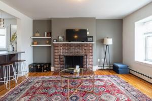een woonkamer met een stenen open haard met een glazen tafel bij Beautiful & Spacious Apt AC, Unit #1 in Halifax
