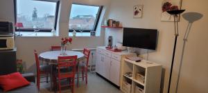 une cuisine avec une table, une télévision et une salle à manger dans l'établissement Studio Cosy, à La Roche-Posay
