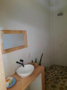 een badkamer met een wastafel en een spiegel op een aanrecht bij Casa kuxtal in Zipolite