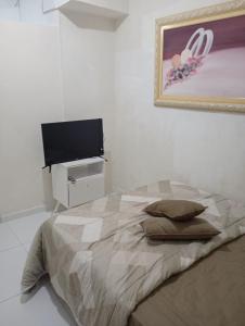 een slaapkamer met een bed en een flatscreen-tv bij Marreal in Arraial do Cabo