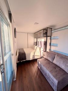 a bedroom with a bed and a couch in a room at Sendero Nativo Glamping in Monguí