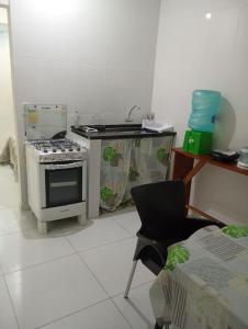 een keuken met een fornuis en een stoel. bij Marreal in Arraial do Cabo +3 foto's