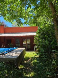 a red building with a bench in front of it at Nido Rústico in Rivera +25 photos