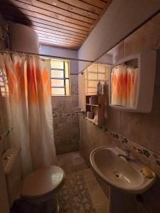 a bathroom with a sink and a toilet and a mirror at Nido Rústico in Rivera