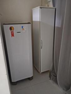 een witte koelkast in een keuken naast een muur bij Marreal in Arraial do Cabo