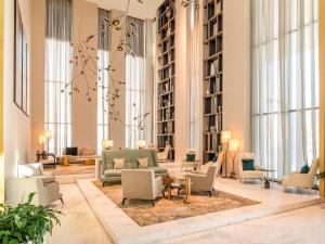 een grote lobby met banken, stoelen en ramen bij Fairmont Ramla Riyadh in Riyad