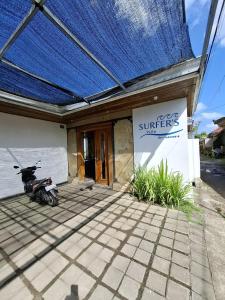a motorcycle parked outside of a building with a blue roof at suffers villa medewi in Medewi