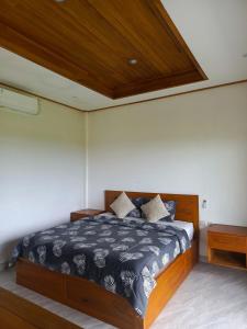 a bedroom with a bed and a wooden ceiling at suffers villa medewi in Medewi