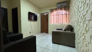 a living room with a couch and a television at Casa Aconchegante Uberlândia in Uberlândia