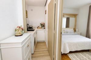 een kleine keuken met witte kasten en een bed bij Appartement F1 F2 in Drancy +7 foto's