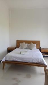 a large bed with white sheets and pillows at suffers villa medewi in Medewi