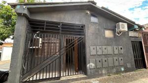 a building with an open gate in the side of it at Casa Aconchegante Uberlândia in Uberlândia