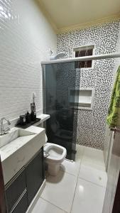 a bathroom with a toilet and a sink and a shower at Casa Aconchegante Uberlândia in Uberlândia +20 photos