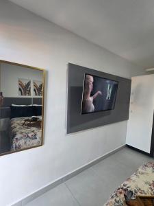 een slaapkamer met een tv aan de muur bij Home Easy Flat in Volta Redonda