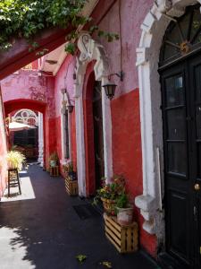 a red and white building with a black door at Casona Cruz Verde in Arequipa