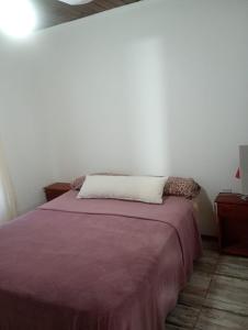 una camera con un letto e una coperta viola di Lilemar a Miramar