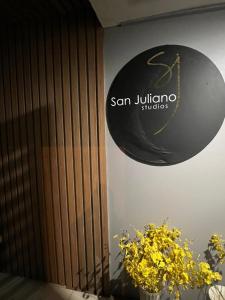 a sign on the side of a building with flowers at San Juliano Studios in Foz do Iguaçu