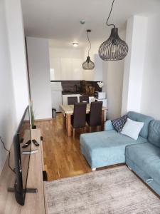 a living room with a blue couch and a table at Mountain View -ski & mountain retreat, Apartment 01 PRIZEMLJE u Premium objektu in Jahorina +13 photos