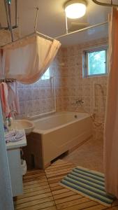 une salle de bains avec baignoire et lavabo dans l'établissement Big Tree JUDO ハウス, à Urazoe