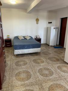 Schlafzimmer mit einem Bett und einem Kühlschrank in der Unterkunft Único loft con pileta cerca de Villa Carlos Paz in San Antonio de Arredondo