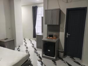 een slaapkamer met een bed en een zwarte deur bij Bumi Geulis Hotel & Residence in Sukabumi