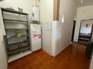 a small kitchen with a refrigerator and a counter at Alquiler temporal Colonia Caroya in Colonia Caroya