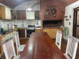 a kitchen with a long wooden table and chairs at Alquiler temporal Colonia Caroya in Colonia Caroya +3 photos