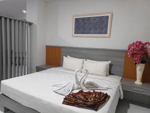 een hotelkamer met een bed met een zwaan erop bij Bumi Geulis Hotel & Residence in Sukabumi