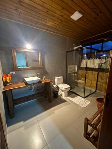 a bathroom with a toilet and a sink and a shower at Pousada Morada Canto do Sol in São Bento do Sapucaí +92 photos
