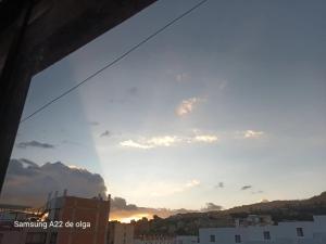 a view of the sunset from the window of a building at Casa punta del este in Paipa