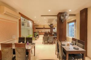 ein Esszimmer mit Holztischen und Stühlen in der Unterkunft Pax Hotel Welcome Inn Opp Railway Station in Amritsar