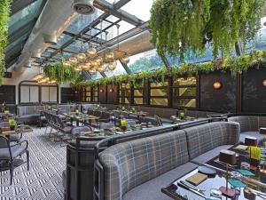 un restaurant avec des tables, des chaises et des plantes dans l'établissement Pullman Singapore Orchard, à Singapour