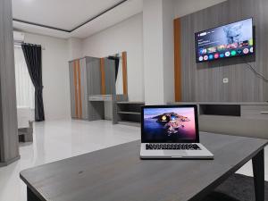 een laptop op een houten tafel in een kamer bij Bumi Geulis Hotel & Residence in Sukabumi