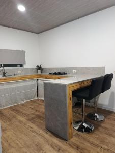 a kitchen with a counter and two chairs at a table at Lofth house in Piriápolis