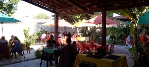 a group of people sitting at tables in a restaurant at Casa da Piscina in Maceió