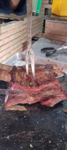 a piece of meat on top of a grill at Casa da Piscina in Maceió