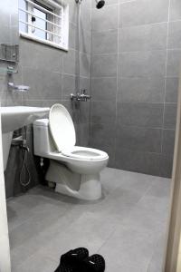 een badkamer met een toilet, een wastafel en een douche bij Legacy Guest House in Islamabad