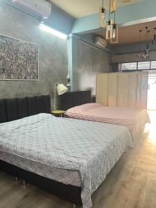 a bedroom with two beds and a table with a lamp at Sea Skyline family in Sattahip